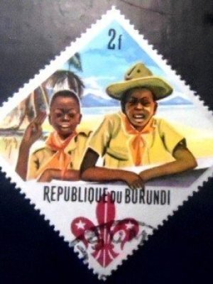 Selo postal do Burundi de 1967 Boy Scout and Cub Scout giving scout sign 2 MCC